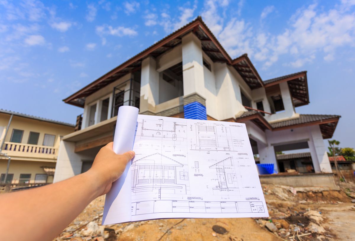 architecture drawings in hand on big house building